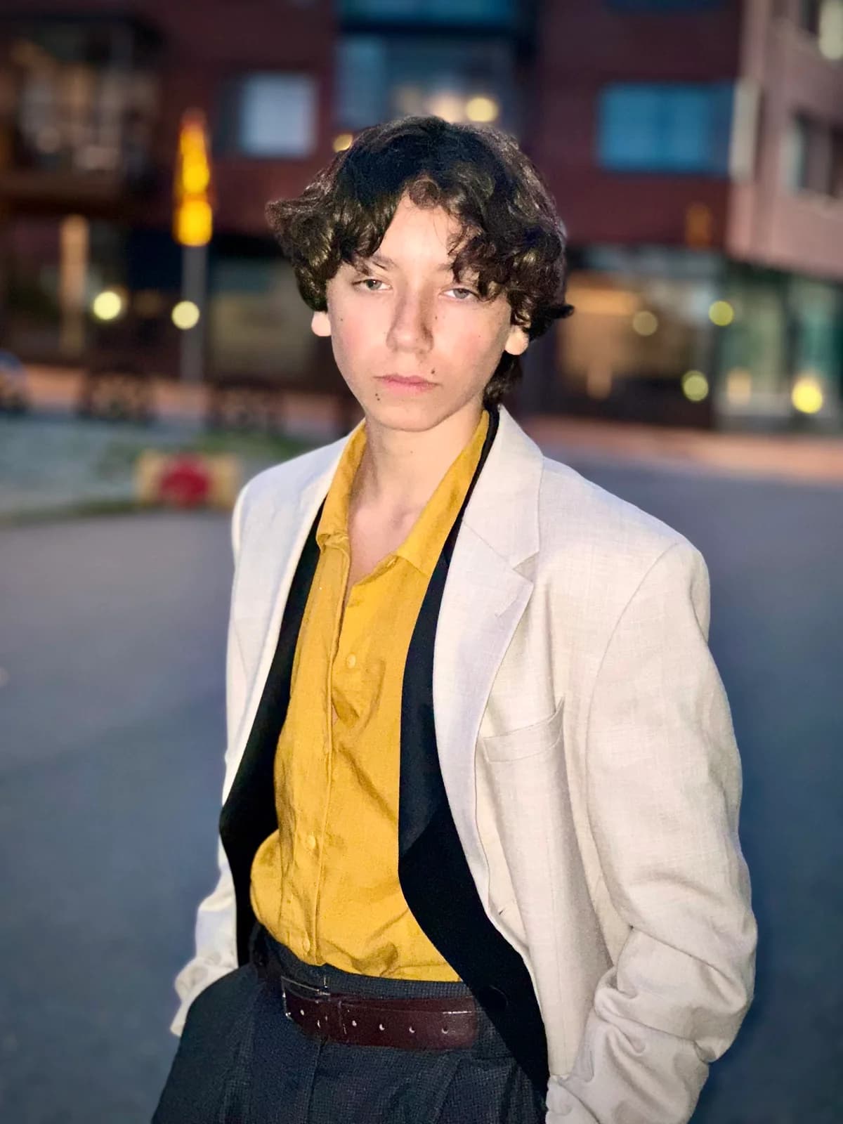Enki, veste claire et chemise jaune.
